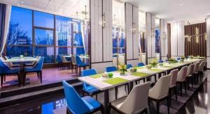 海口市にあるHampton by Hilton Nanhai Haikouの長いダイニングルーム(テーブル、青い椅子付)
