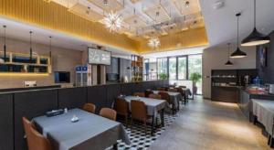 a dining room with tables and chairs in a restaurant at Xiamen Dongchen Hotel in Xiamen
