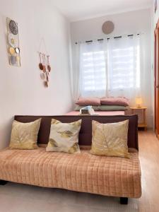 a couch with pillows in a room with two beds at Cozy Condo near Mactan Airport - Free Wifi! in Lapu Lapu City