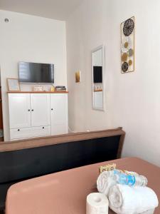 a room with a table and a tv on a wall at Cozy Condo near Mactan Airport - Free Wifi! in Lapu Lapu City +4 photos