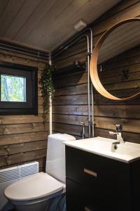 Un baño con inodoro, lavabo y espejo. en Aava Riverside, en Rovaniemi