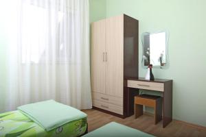 a bedroom with a bed and a dresser with a mirror at Apartments Eufemija in Novalja