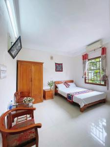a bedroom with a bed and a chair in it at Mai Chau Hostel in Mai Chau