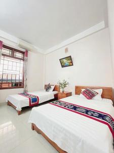 a bedroom with two beds and a window at Mai Chau Hostel in Mai Chau