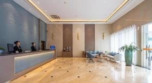 two men standing at a reception desk in a lobby at Uniton Hotel Shenzhen in Shenzhen