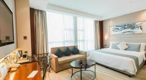 sypialnia z łóżkiem i kanapą w pokoju w obiekcie Grand Soluxe Zhongyou Hotel Shenzhen w mieście Shenzhen +127 zdjęć