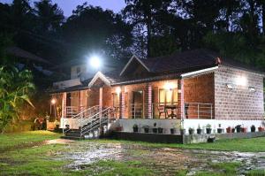 奇克马格尔Arabica Aura Homestay的一间晚上有灯的小砖房子 更多11张照片