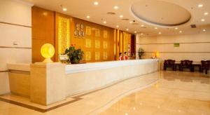 a lobby with a waiting area with a yellow wall at Zhongshan Hui Quan Hotel in Zhongshan