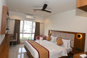 a hotel room with a bed and a chair at Good One Suites in Bengaluru +24 photos