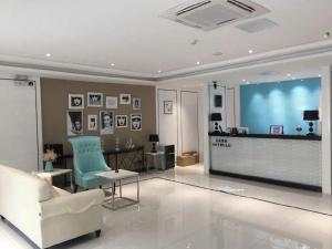 a living room with a couch and a large screen at Xana Hotelle· Tianjin Railway Station Jinwan Square Binjiang Avenue in Tianjin
