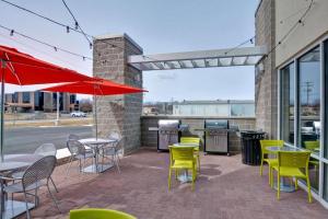 a patio with tables and chairs and a grill at Home2 Suites by Hilton Green Bay in Green Bay