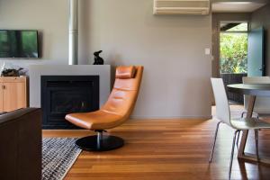 un soggiorno con sedia e camino di Daylesford Spa Villa 6 - 1 bedroom a Daylesford 1 altra foto