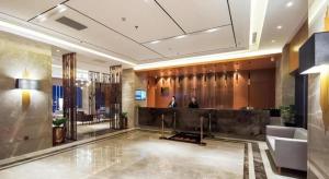 a lobby of a hotel with a man standing in it at Yitel Collection Shenyang North Railway Station Metro Station in Shenyang