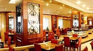 a restaurant with tables and chairs and a bar at Heilongjiang Kunlun Hotel in Harbin