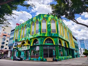 un bâtiment vert et jaune dans une rue de la ville dans l'établissement Hotel Ma'Wa By Salaam Suites, à Kota Bharu