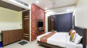 a bedroom with a bed and a brick wall at The Kumar inn in Dānāpur