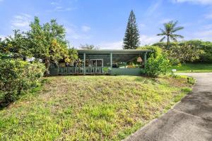 a green house with a fence in a yard at International Colony Club 28 · ICC 28 Remodeled 2BD Cottage in K in Lahaina