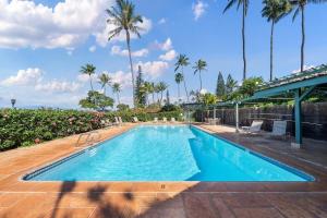 ラハイナにあるInternational Colony Club 28 · ICC 28 Remodeled 2BD Cottage in Kのヤシの木が背景に広いスイミングプール