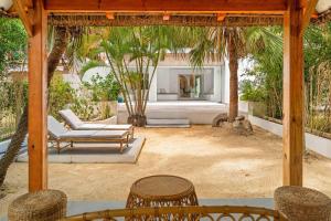 a patio with a table and chairs and palm trees at Villa Kayou by Sealodge Mauritius in Tamarin