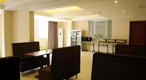 a room with a table and chairs and a kitchen at GreenTree Inn Chengdu North Railway Station Beichengtianjie Business Hotel in Chengdu