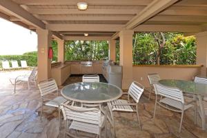 a patio with two tables and chairs and a kitchen at Paki Maui 301 · Direct Oceanfront Views Remodeled 2BD Condo in Kahana