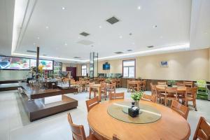a dining room with tables and chairs and a restaurant at GreenTree Inn Taiyuan PinGYAng Road Business Hotel in Taiyuan