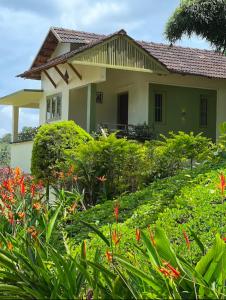 a house with a garden in front of it at Ayurnest Pool Resort Wayanad in Batheri