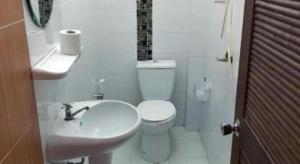 une salle de bain blanche avec toilettes et lavabo dans l'établissement Remember Loei Love, à Chiang Khan