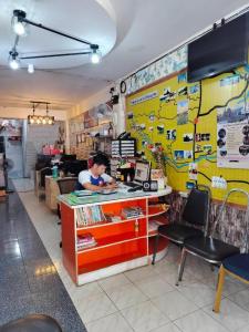 una persona que trabaja en el mostrador de un restaurante en Sofia Hostel, en Chiang Rai