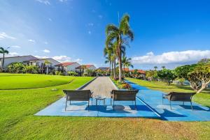 three chairs and a table in a park at Maui Hill 66 · MHL 66 3BD Condo Across from Keawakapu Beach & St in Wailea
