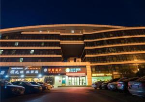 a large building with cars parked in front of it at City Comfort Inn Wuhan High Speed Railway Station in Wuhan