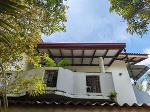 a white house with a red roof at Thaksilu Home in Mirissa