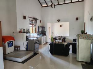 a living room with two chairs and a kitchen at Thaksilu Home in Mirissa