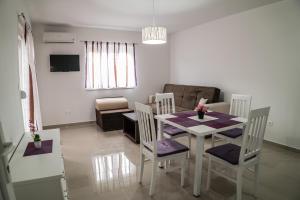 a dining room and living room with a table and chairs at Apartments Malina in Vir
