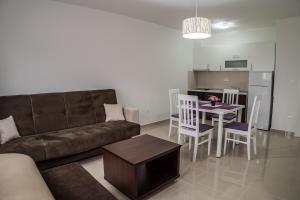 a living room with a couch and a table and a kitchen at Apartments Malina in Vir