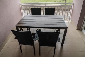 a wooden table with four chairs on a balcony at Apartments Malina in Vir +1 photo