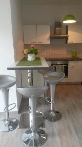 a kitchen with three bar stools and a counter at House Lavanda in Rab