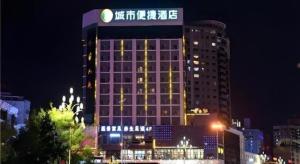 a tall building with a sign on it at night at City Comfort Inn Kunming Cuihu Hospital of Yunnan University Panjiawan Metro Station in Kunming