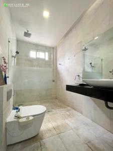a bathroom with a white toilet and a sink at NEW LAND Apartment - Phu My Hung in Ho Chi Minh City