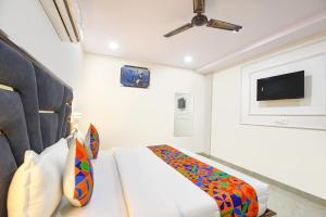 a bedroom with a bed and a flat screen tv at FabHotel Tulip Sarover in New Delhi