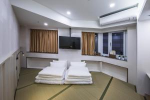 a room with two white pillows and a flat screen tv at Apause Inn in Taipei +34 photos