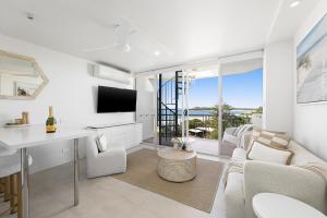 a living room with a couch and a table at Sandcastles Mooloolaba in Mooloolaba