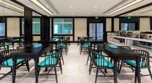 a dining room with black tables and chairs at Xana Hotelle·Xiamen Railway Station in Xiamen