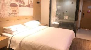 a hotel room with a white bed and a bathroom at City Comfort Inn Wuhan Baibuting in Wuhan +176 photos
