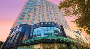 a tall building with a sign on the side of it at Kunming Wenhui Hotel in Kunming