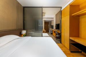 a bedroom with a large bed and a sliding glass door at Guangzhou XiErXiDun International Apartment（Pearl River New Town, U.S. Consulate Branch） in Guangzhou