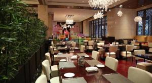 a dining room with tables and chairs and chandeliers at Weida Hotel Jinhua in Jinhua