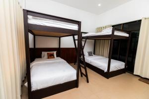 巴色Nisa hostel的配有白色床单的客房内的两张双层床