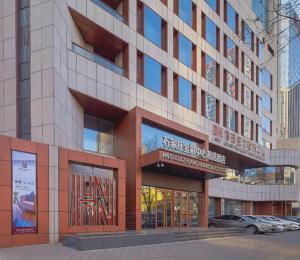 a large building with a sign in front of it at NH Shijiazhuang Financial Center in Shijiazhuang