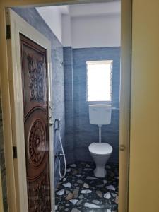 a bathroom with a toilet and a window at Hotel Seven Heaven in mayapur +19 photos
